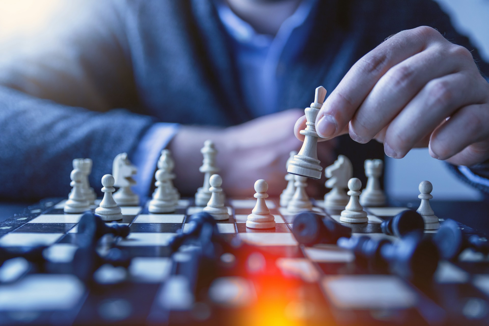 A man in a suit playing chess to represent a good BEE Strategy as a service.