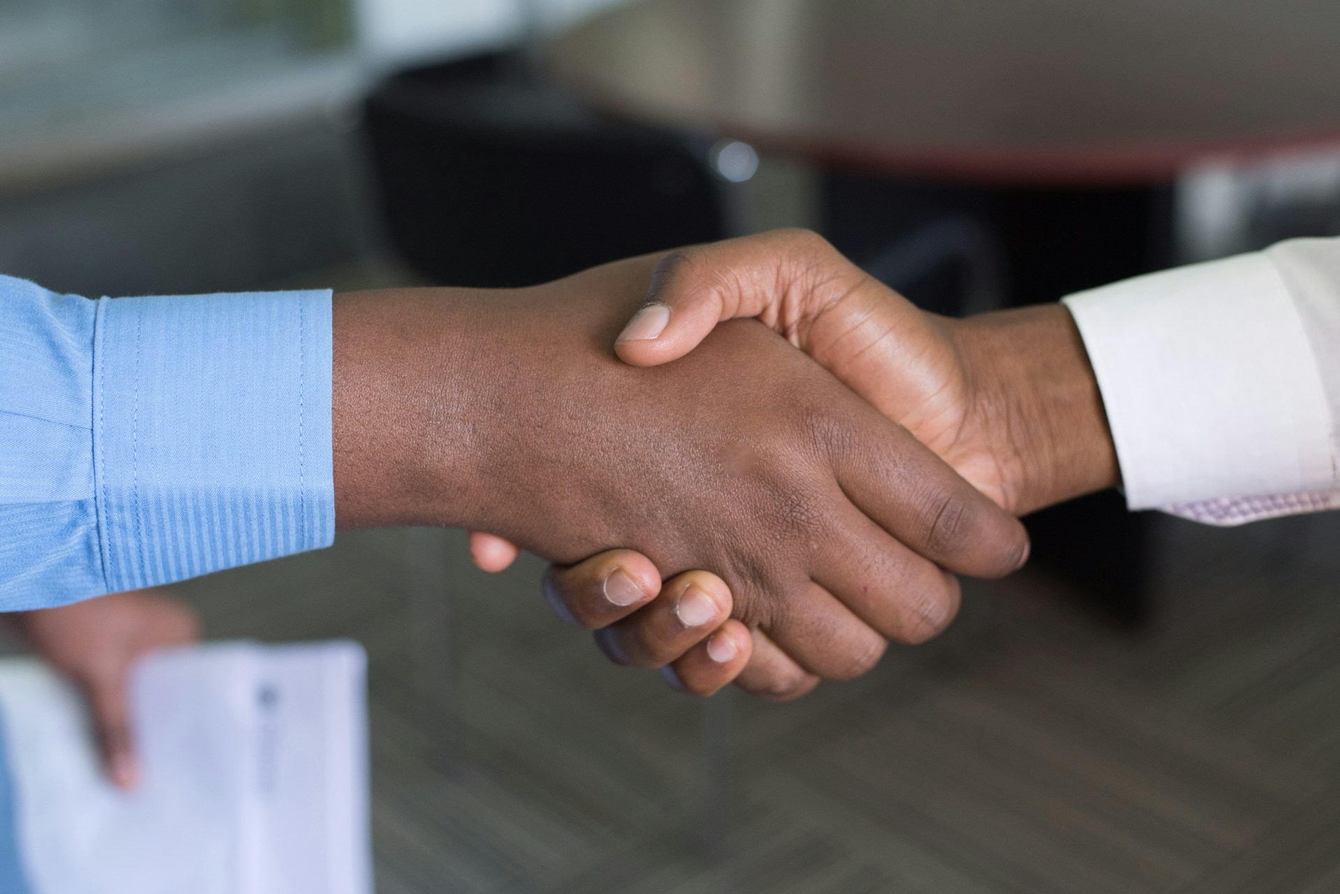 Supplier development represented by 2 black men shaking hands.